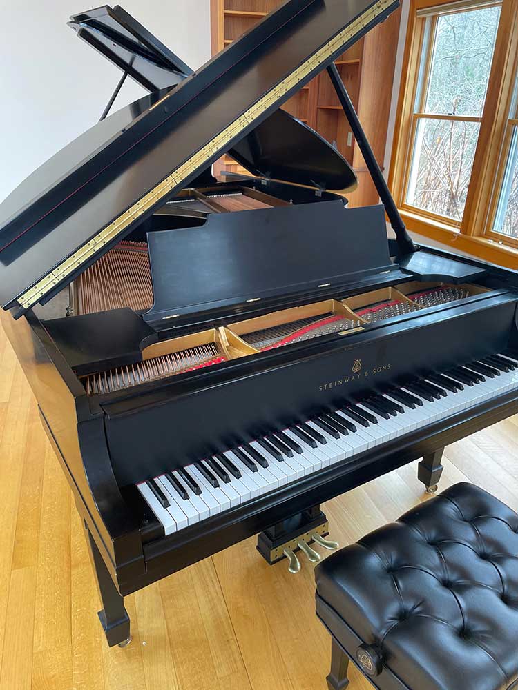 a fully restored grand piano with top open in Cape Cod Studio